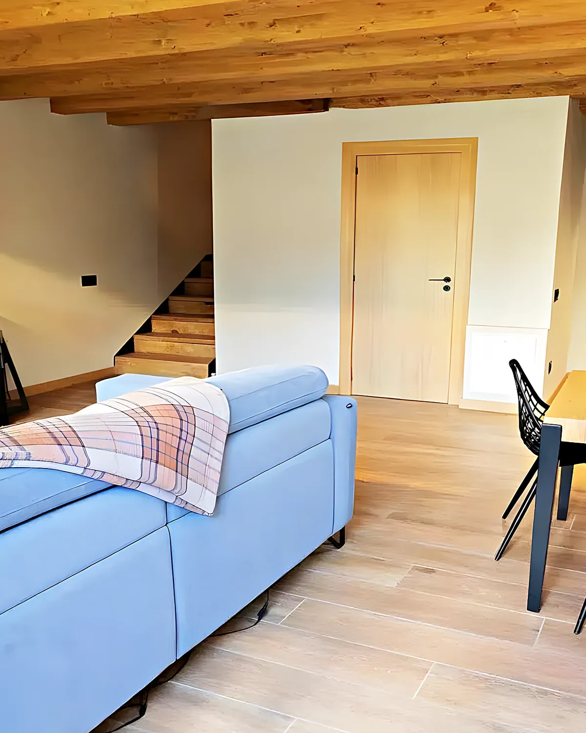 Salón con chimenea de leña y comedor de madera en una casa de Cubelles reformada para vivir todo el año
